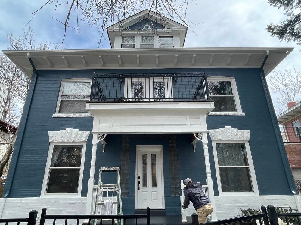 Elmwood Painting crew member finishing a two story exterior
