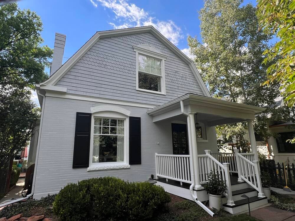 Freshly painted light grey home with white trim by Elmwood Painting
